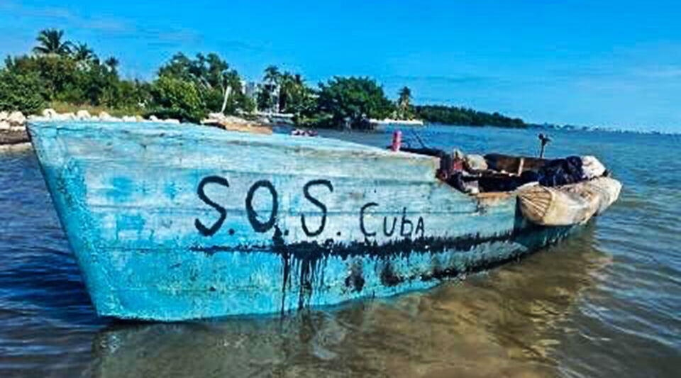 15 rafters arrive in the Florida Keys in a boat with the legend SOS Cuba