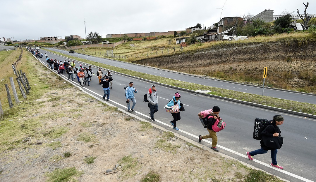 Migrantes venezolanos caminando en vías ecuatorianas luego de cruzar la frontera con Colombia y en camino hacia Perú.