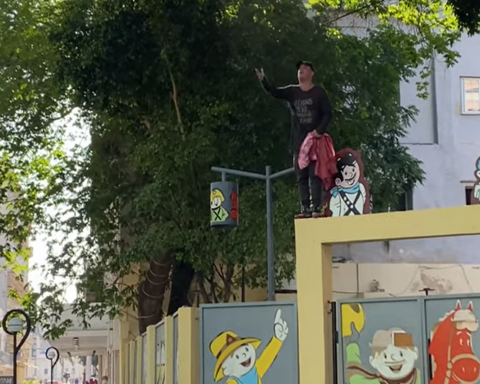 Climbing on a wall in Centro Habana, an activist asks for freedom for Cubans