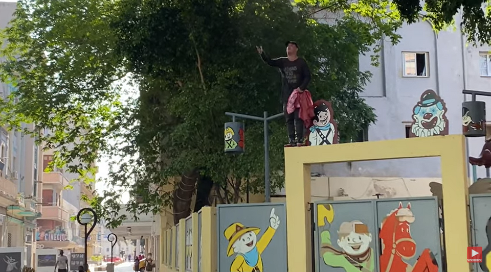 Climbing on a wall in Centro Habana, an activist asks for freedom for Cubans
