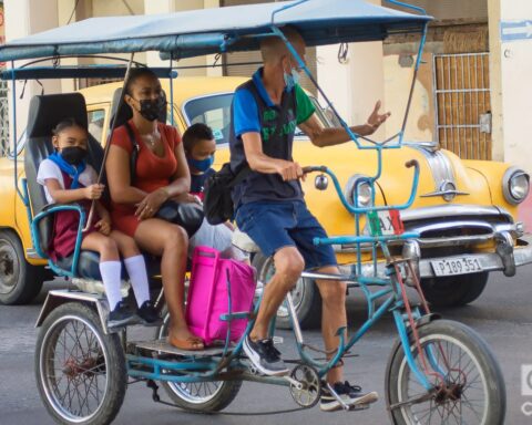 Una madre lleva a sus hijos a la escuela en un bicitaxi, en La Habana. Foto: Otmaro Rodríguez.