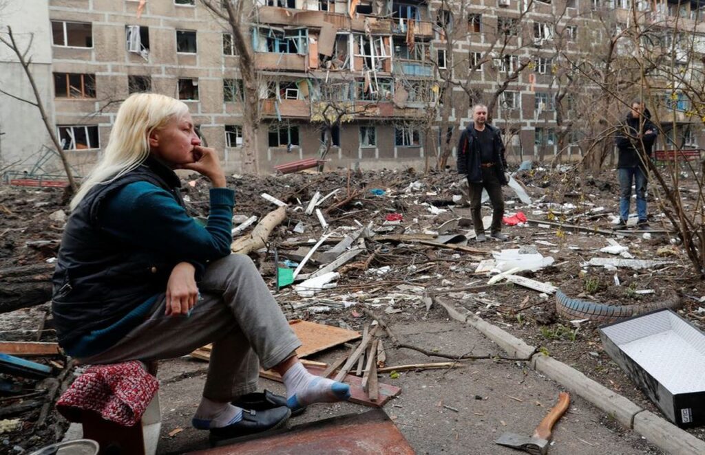 Un grupo de residentes locales se reúnen en un patio cerca de un bloque de viviendas  en Mariupol, Ucrania,  el 18 de abril de 2022.