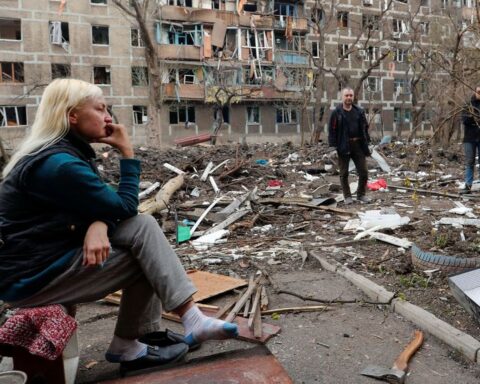 Un grupo de residentes locales se reúnen en un patio cerca de un bloque de viviendas  en Mariupol, Ucrania,  el 18 de abril de 2022.