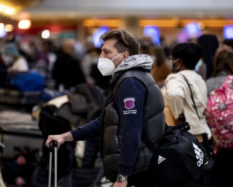 Pasajeros se protegen con mascarillas en el Aeropuerto Internacional de Los Ángeles, Estados Unidos. Foto: Etienne Laurent /EFE.
