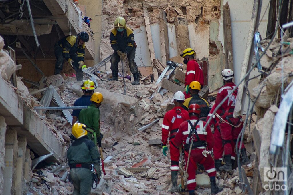 Miembros de la Cruz Roja cubana (de rojo) participan junto a bomberos y otras fuerzas en las labores que se realizan tras la explosión del hotel Saratoga, en La Habana. Foto: Otmaro Rodríguez.