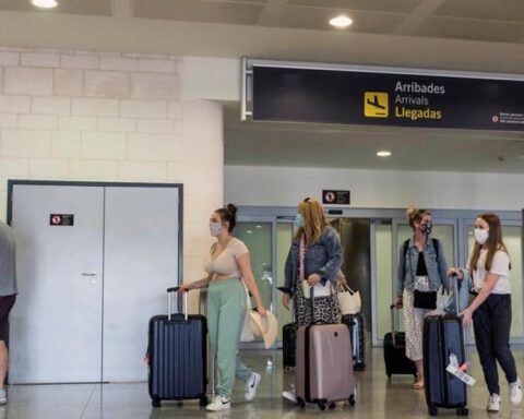 Turistas con nasobucos llegan al aeropuerto de Menorca en un vuelo procedente de Londres. Foto: EFE.