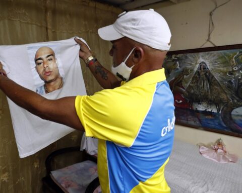 Omar Quintero, el cubano conocido como "el pagador de promesas", muestra la imagen de su hijo enfermo impresa en una camiseta durante una entrevista en La Habana. Foto: Ernesto Mastrascusa / EFE.