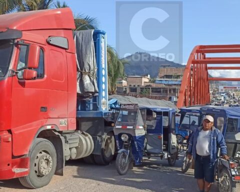 Heavy cargo carriers block the entrance bridge to the Pichanaqui district