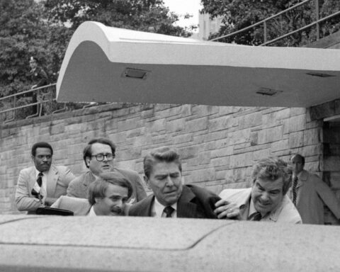 Instante en que el ex presidente Ronald Reagan era empujado hacia dentro de la limusina tras los disparos. Foto: Ron Edmonds / AP (Archivo).