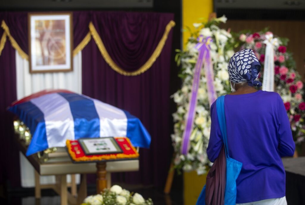 Una mujer observa el féretro del pianista cubano César "Pupy" Pedroso durante las honras fúnebres en el vestíbulo del Teatro Nacional, en La Habana, el 22 de julio de 2022. Foto: EFE / Yander Zamora.