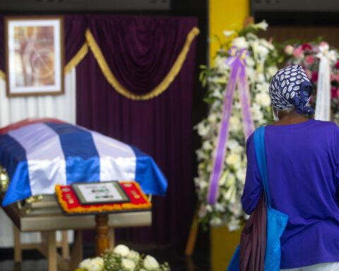 Una mujer observa el féretro del pianista cubano César "Pupy" Pedroso durante las honras fúnebres en el vestíbulo del Teatro Nacional, en La Habana, el 22 de julio de 2022. Foto: EFE / Yander Zamora.