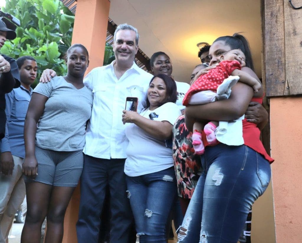 President Luis Abinader together with several women who have benefited from the new homes in Arenoso.