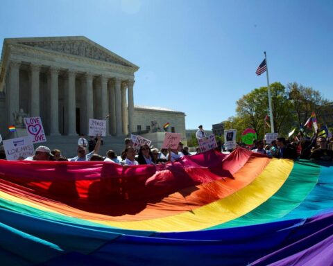 Manifestantes con una bandera del arcoiris ante la Corte Suprema de Washington el 28 de abril de 2015, cuando se deliberaba sobre el matrimonio entre personas del mismo sexo en el caso Obergefell v. Hodges. Foto: AP.