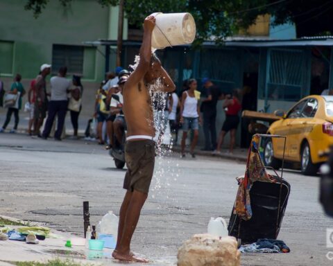 Un hombre se baña en plena calle para refrescarse del calor, en La Habana. Foto: Otmaro Rodríguez.