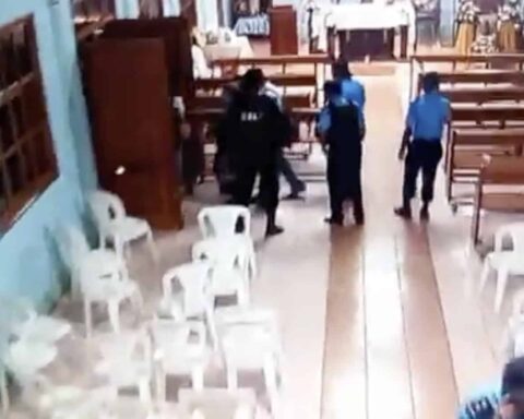 Priest Uriel Vallejos and parishioners leave the temple besieged by the Police