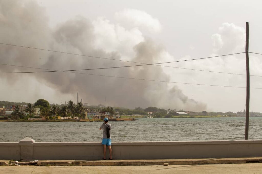 Hombre observa el humo del incendio en Base de Supertanqueros, Matanzas, martes 9 de agosto. Foto: Sergio Martínez.