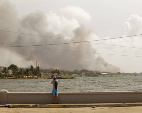 Hombre observa el humo del incendio en Base de Supertanqueros, Matanzas, martes 9 de agosto. Foto: Sergio Martínez.