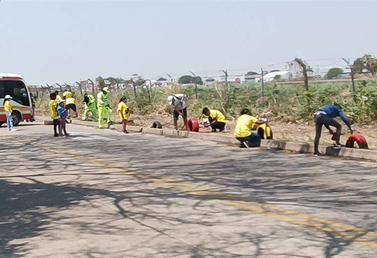 Neighbors clean the edge of the mesh of El Trompillo airport