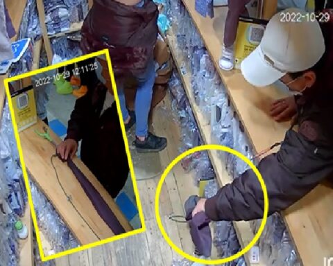 "With clamp picks up objects", thief grabs and takes cell phones and other objects in clothing stores