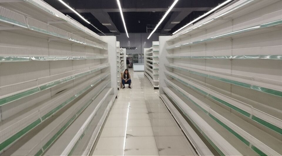 A depressed employee in the middle of empty shelves, a reflection of Cuba's misfortune