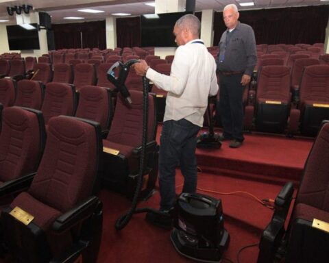 An employee of the National Congress cleans the seats in the National Assembly Hall for the rendering of accounts of President Luis Abinader