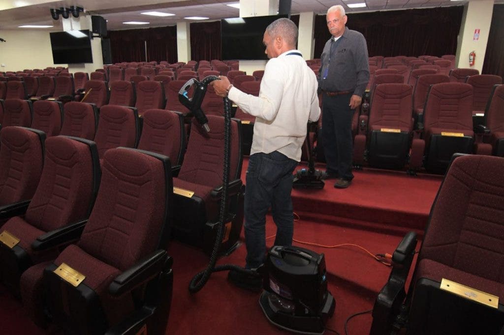 An employee of the National Congress cleans the seats in the National Assembly Hall for the rendering of accounts of President Luis Abinader