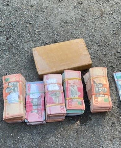 Money and cocaine seized by DNCD in two vehicles.