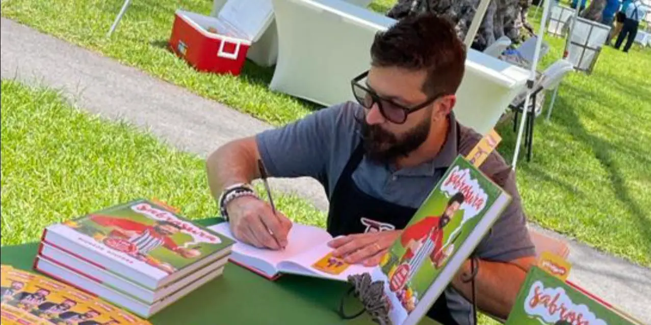 Ricardo Becerra firmando su libro 'Sabrosura' en Miami