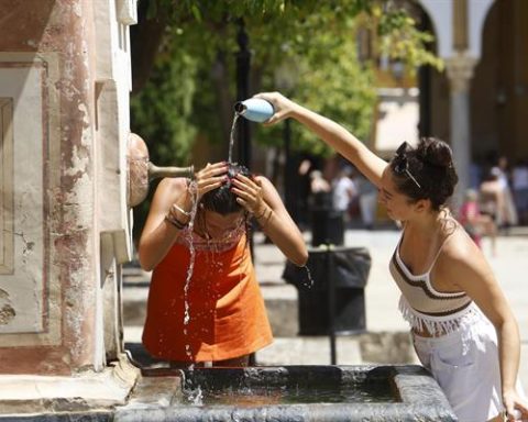 Dos mujeres se refrescan en una fuente del Patio de los Naranjos de la Mezquita Catedral de Córdoba. EFE/Salas