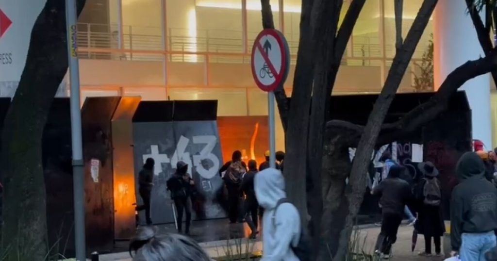 Hooded men destroy establishments during the march through Ayotzinapa