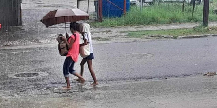 Dos mujeres se protegen de las lluvias provocadas por el huracán Helene en el occidente de Cuba