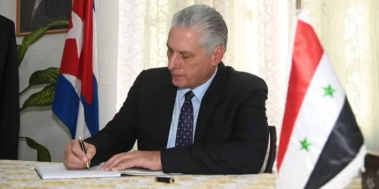 Miguel Díaz-Canel, entre las banderas de Cuba y Siria