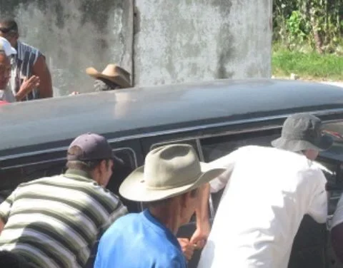 Cubanos empujando un carro fúnebre