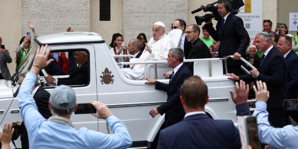 Pope Francis greets the crowd from the Papamobo