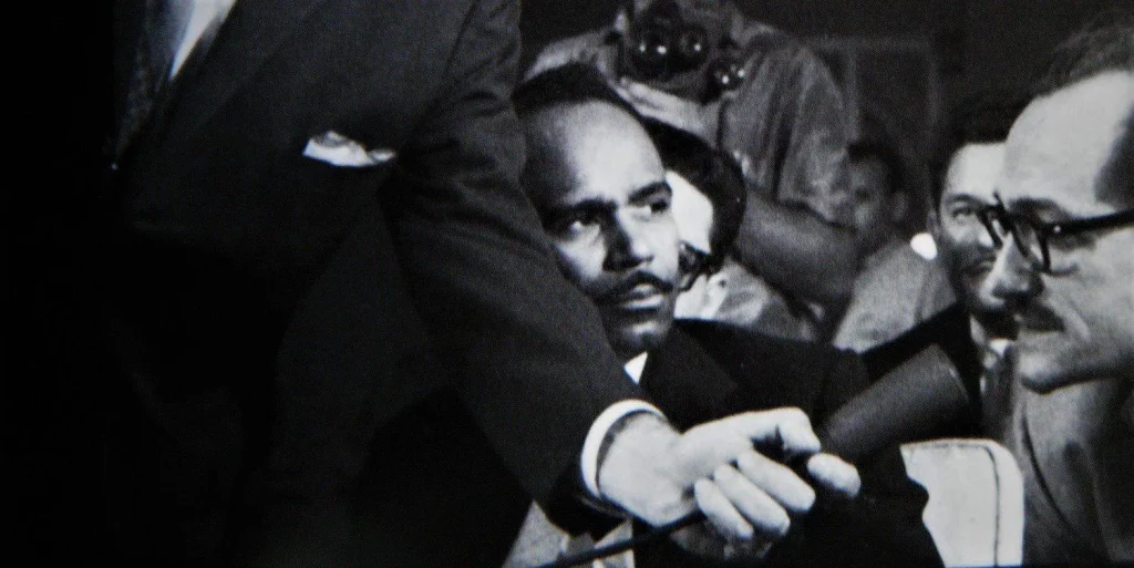 Walterio Carbonell viendo hablar a José Barbeito durante una entrevista colectiva a Jean-Paul Sartre en La Habana, en 1960