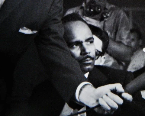 Walterio Carbonell viendo hablar a José Barbeito durante una entrevista colectiva a Jean-Paul Sartre en La Habana, en 1960