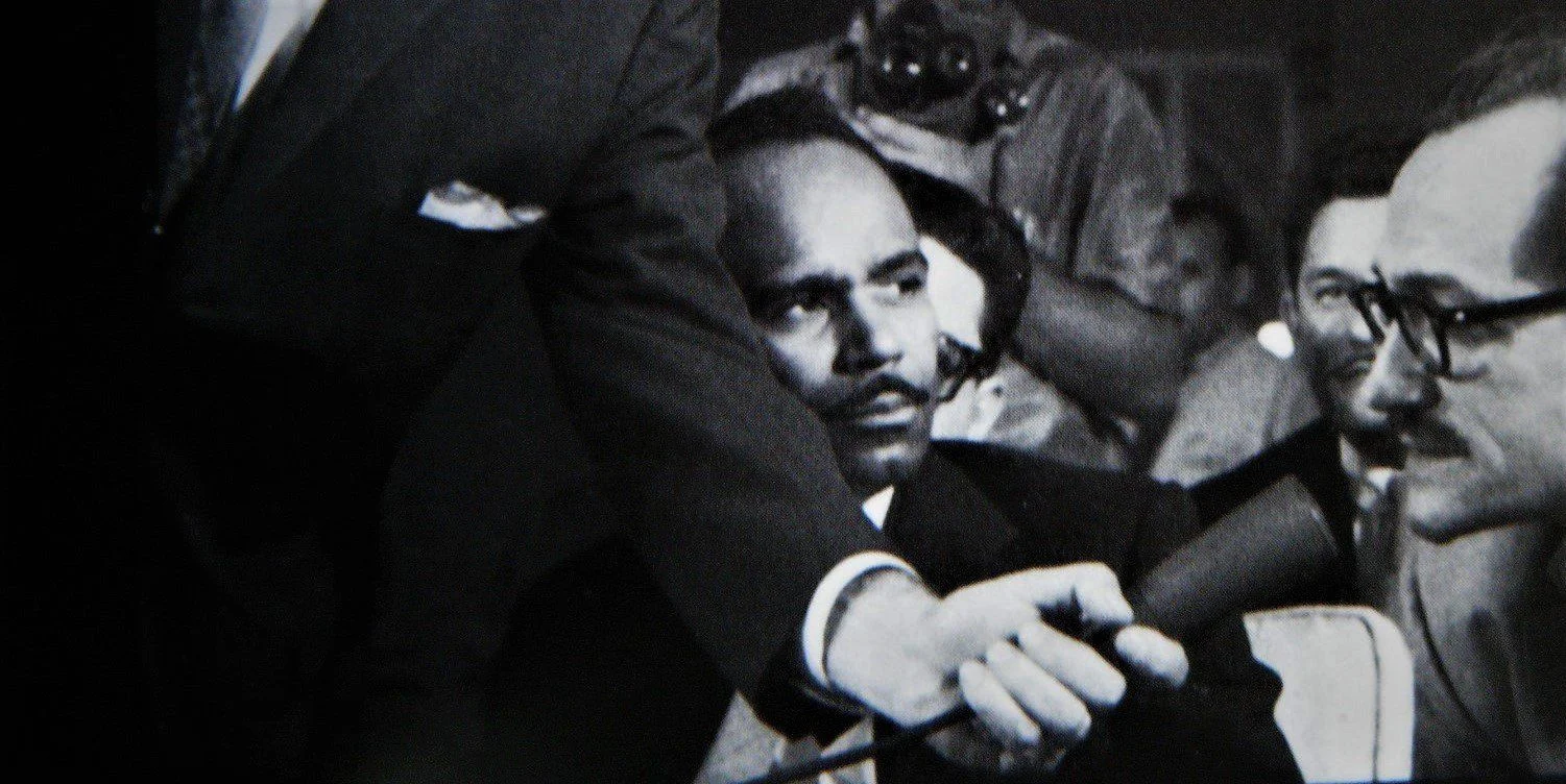 Walterio Carbonell viendo hablar a José Barbeito durante una entrevista colectiva a Jean-Paul Sartre en La Habana, en 1960