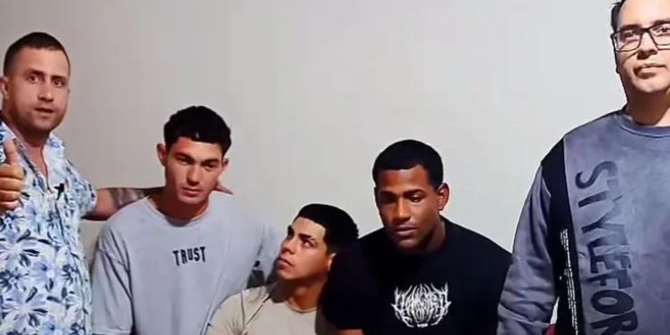 Los tres atletlas cubanos (centro) junto a dos activistas