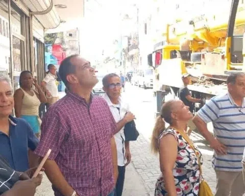 Transeúntes y trabajadores observan el edificio que sufrió un derrumbe parcial, este martes