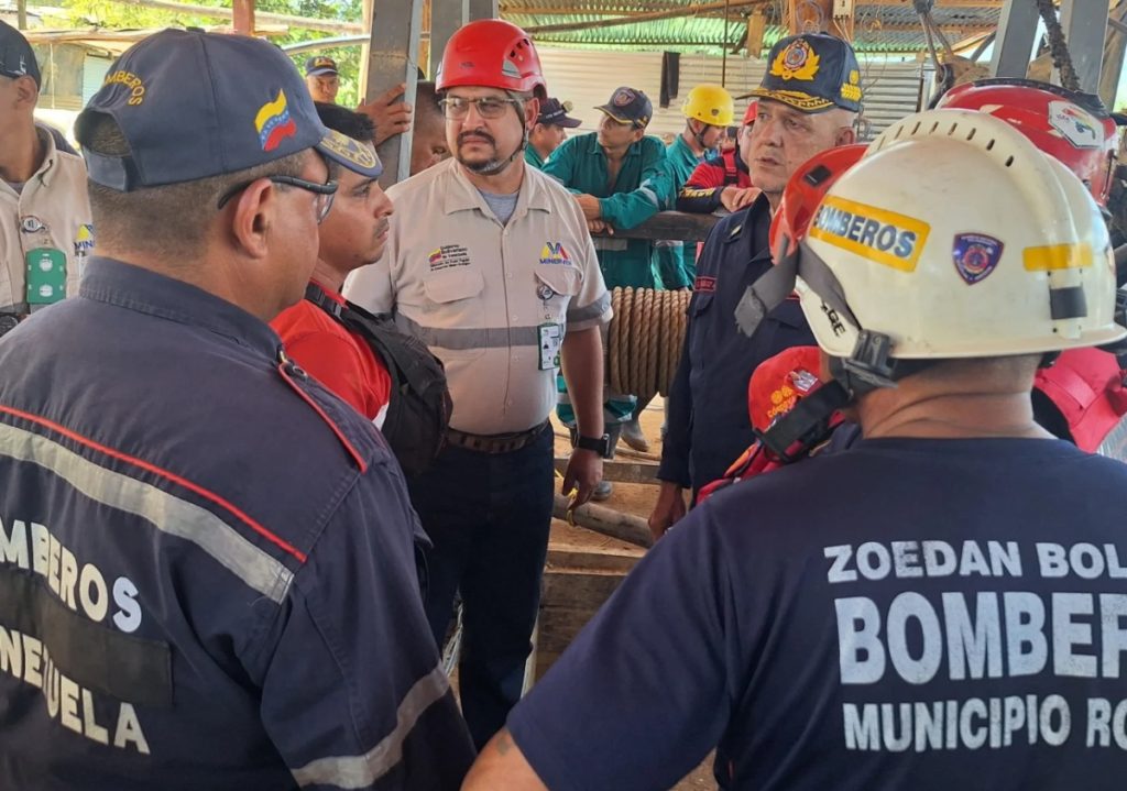 Firefighters rescue the bodies of 14 miners who died due to flooding in the El Callao mine