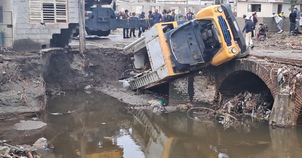 A truck falls off a bridge with its load of two electrical transformers