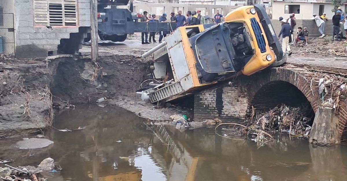 A truck falls off a bridge with its load of two electrical transformers