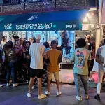 Jóvenes frente a la entrada del bar Estocolmo, en la ciudad de Guantánamo