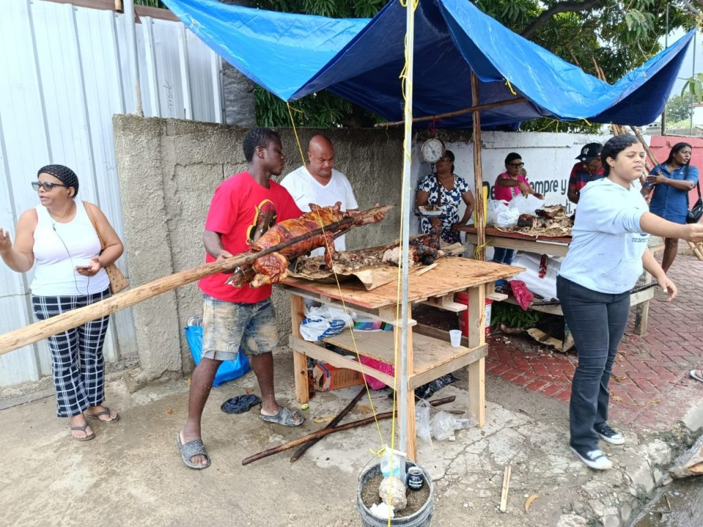 Citizens in Puerto Plata purchase roast pork and other items for the traditional Christmas Eve dinner