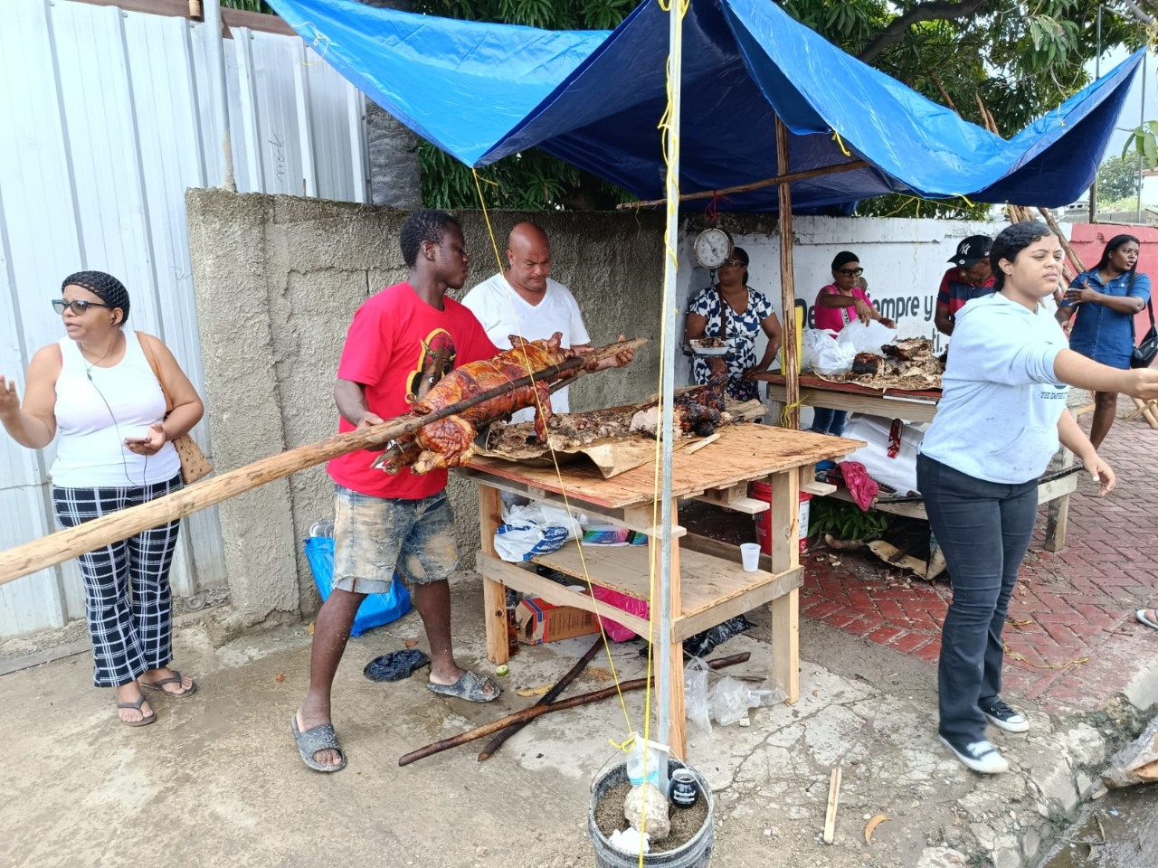 Citizens in Puerto Plata purchase roast pork and other items for the traditional Christmas Eve dinner