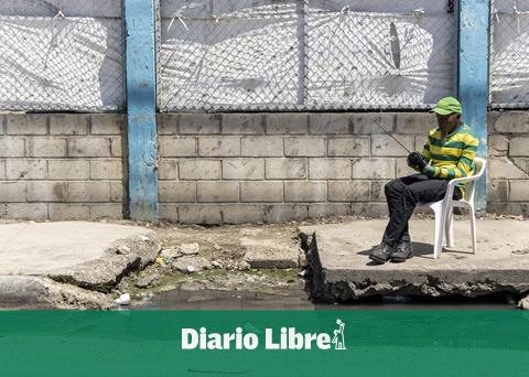 They report danger due to broken sidewalk and blocked drainage in Guaricano