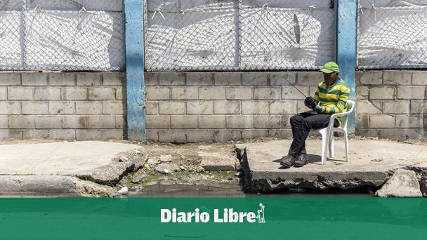 They report danger due to broken sidewalk and blocked drainage in Guaricano