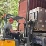 Dos miembros de Cáritas Cuba supervisan el traslado de la ayuda humanitaria