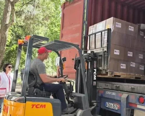 Dos miembros de Cáritas Cuba supervisan el traslado de la ayuda humanitaria