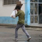 Un hombre se guarece de la lluvia en La Habana